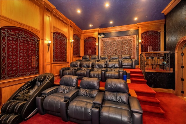 home theater with carpet, wooden walls, and crown molding