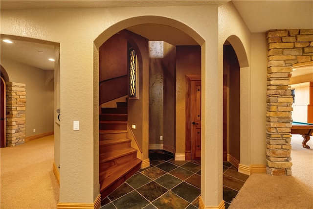 stairway with billiards and dark colored carpet