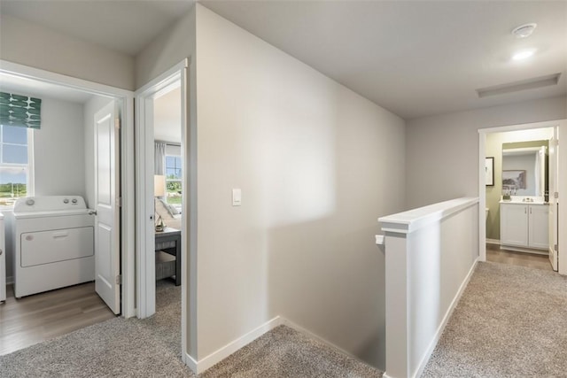 hall with washer / clothes dryer, light carpet, and a wealth of natural light