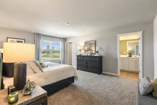 bedroom with light colored carpet and ensuite bathroom