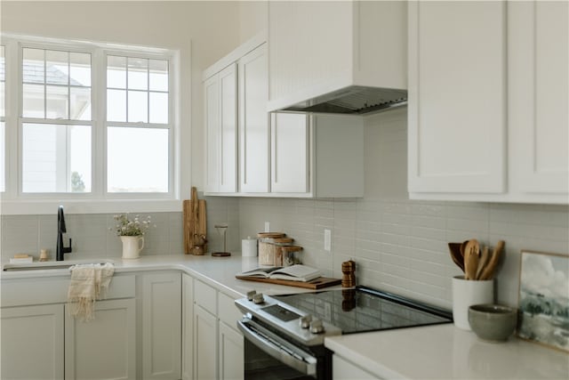 kitchen featuring white cabinetry, stainless steel electric range, and a healthy amount of sunlight