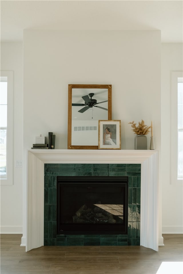 room details featuring ceiling fan, hardwood / wood-style flooring, and a tile fireplace