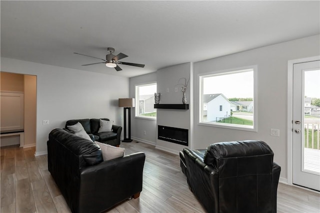 living room with ceiling fan and light hardwood / wood-style floors