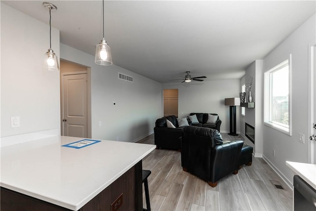 living room with ceiling fan and light hardwood / wood-style flooring