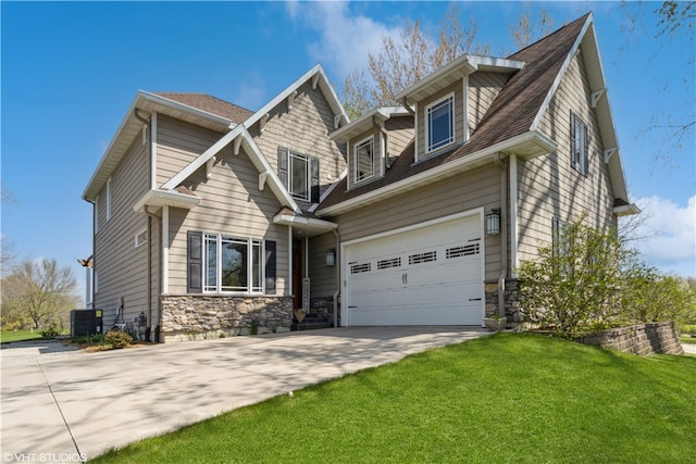 view of front of property with a front yard, a garage, and central AC unit