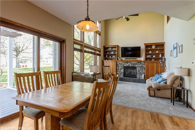 dining space with a fireplace, a healthy amount of sunlight, and light wood-type flooring