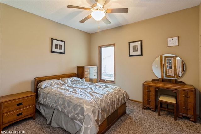 bedroom with ceiling fan and dark colored carpet