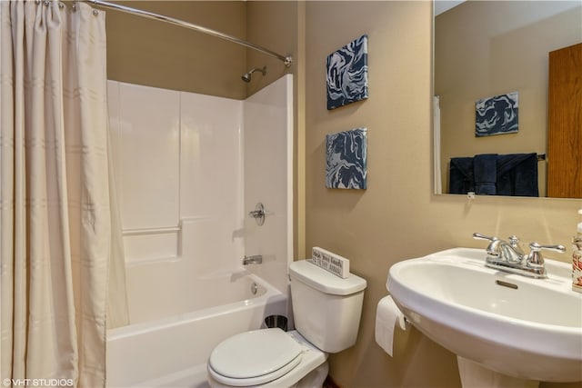 full bathroom featuring shower / bath combo with shower curtain, toilet, and sink