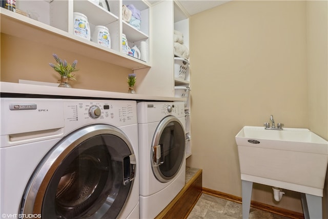 laundry room featuring light tile floors, washer and clothes dryer, and sink