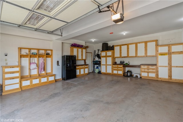 garage featuring a garage door opener and black fridge