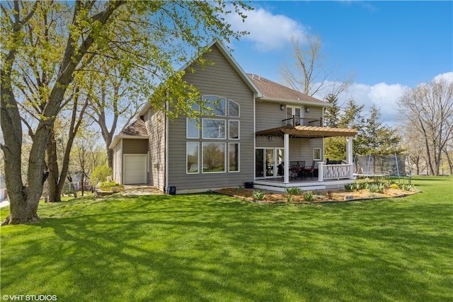 back of property featuring a trampoline and a lawn