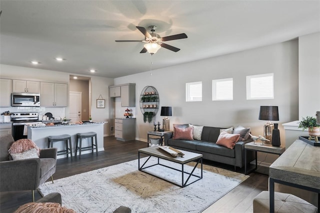 living room with dark wood-type flooring and ceiling fan