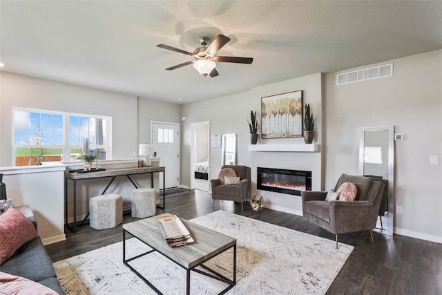 living room with dark hardwood / wood-style floors and ceiling fan