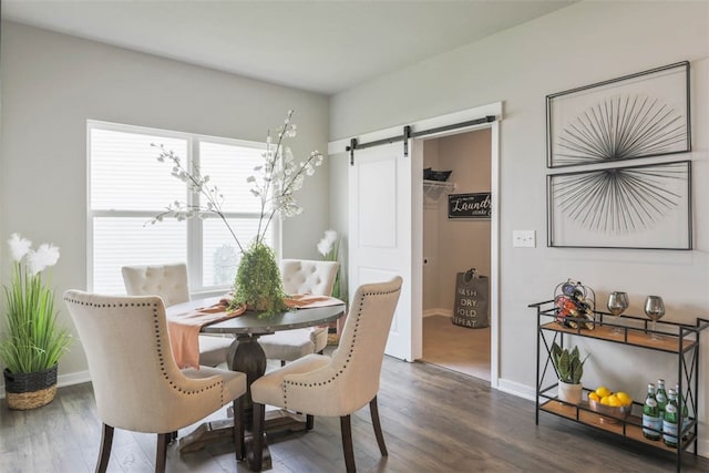 dining room with dark wood-type flooring and a barn door