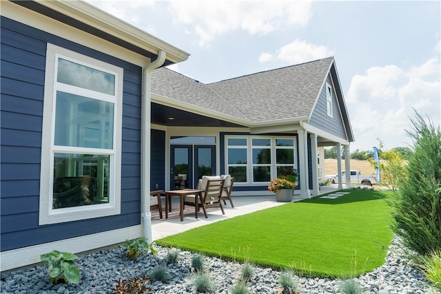 rear view of property featuring a lawn and a patio area