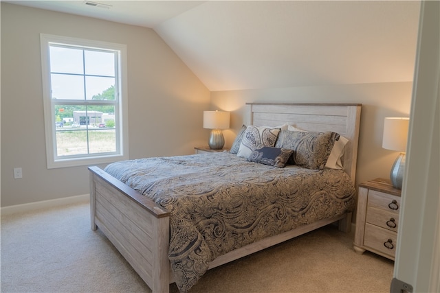 carpeted bedroom featuring lofted ceiling and multiple windows