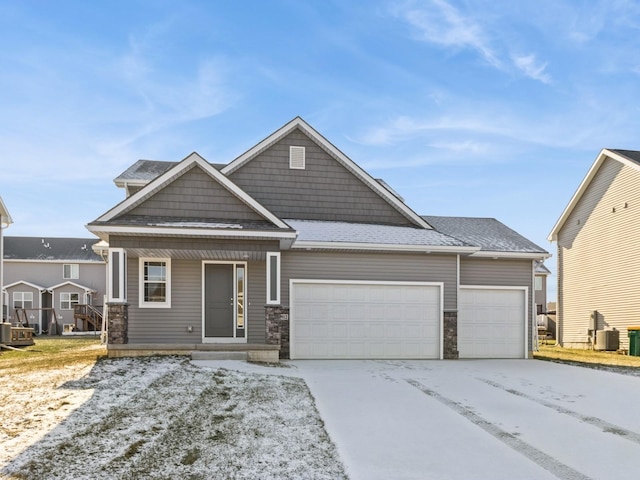 craftsman house with a garage and cooling unit