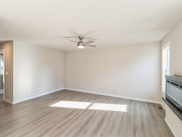 unfurnished living room featuring ceiling fan and light hardwood / wood-style floors