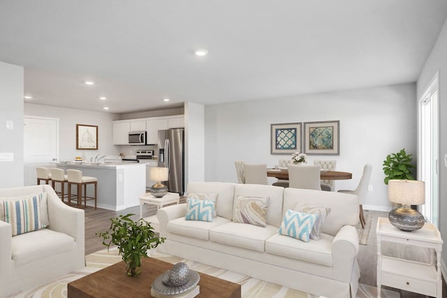 living room with light wood-type flooring and sink