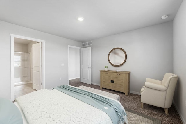 bedroom featuring light colored carpet and connected bathroom