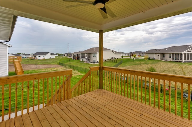 wooden deck featuring a lawn and ceiling fan