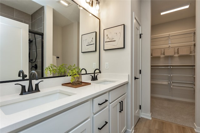 bathroom featuring wood-type flooring, vanity, and an enclosed shower