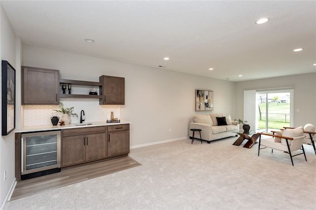 carpeted living room with indoor wet bar and beverage cooler