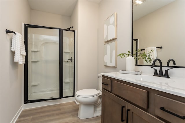 bathroom with hardwood / wood-style floors, vanity, a shower with door, and toilet