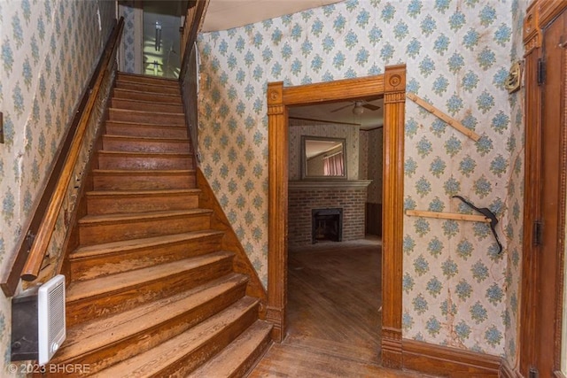 stairs featuring a fireplace and hardwood / wood-style floors