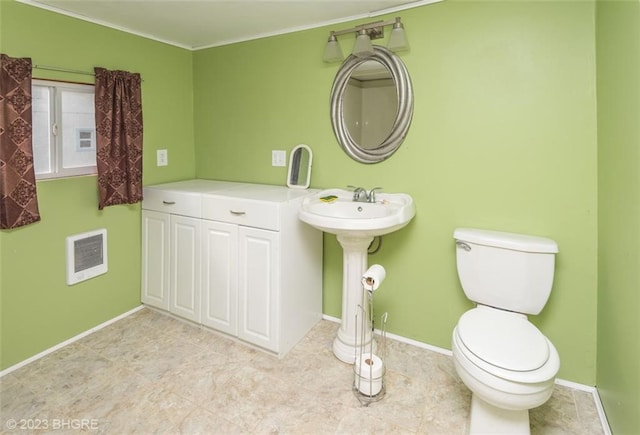 bathroom featuring heating unit, crown molding, and toilet