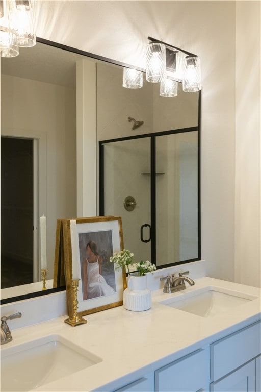 bathroom featuring a notable chandelier, double vanity, and a shower with shower door