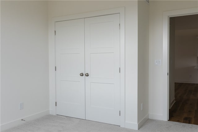 unfurnished bedroom with a closet and light carpet