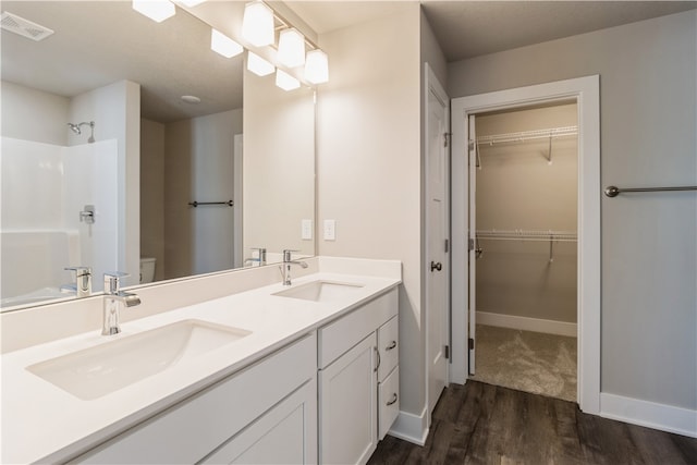 bathroom with vanity, toilet, hardwood / wood-style flooring, and a shower