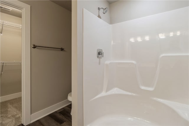 bathroom featuring toilet, hardwood / wood-style floors, and walk in shower