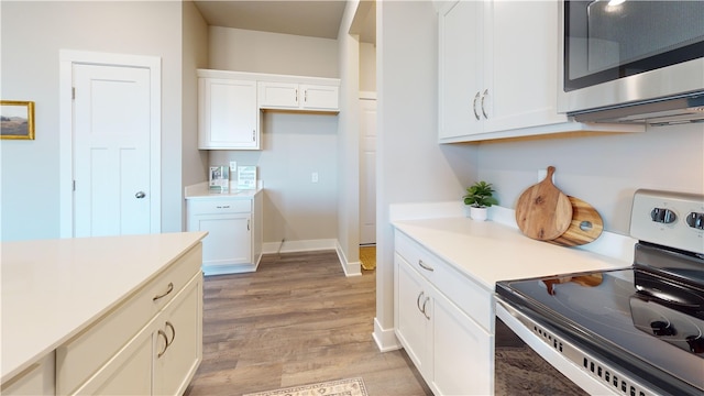 kitchen with white cabinetry, light hardwood / wood-style floors, and range with electric cooktop