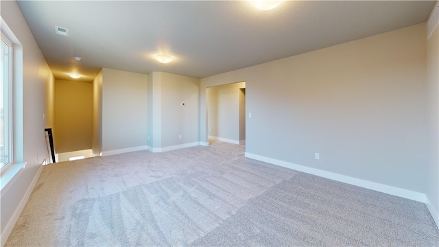 unfurnished room featuring light carpet