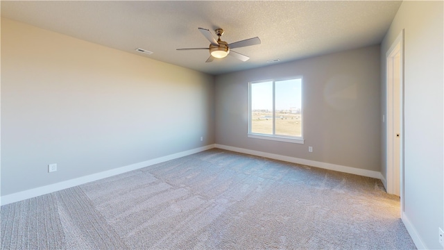 carpeted spare room featuring a textured ceiling and ceiling fan