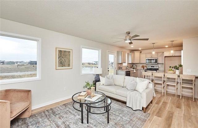 living room featuring ceiling fan and light wood-type flooring