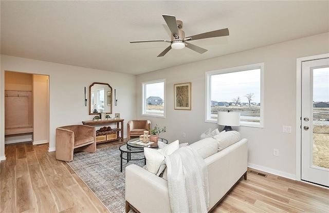 living room featuring ceiling fan and light hardwood / wood-style flooring