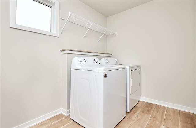 laundry room featuring washing machine and dryer and light wood-type flooring