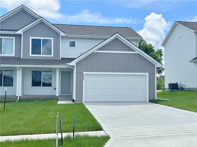 view of front of house with cooling unit, a front yard, and a garage