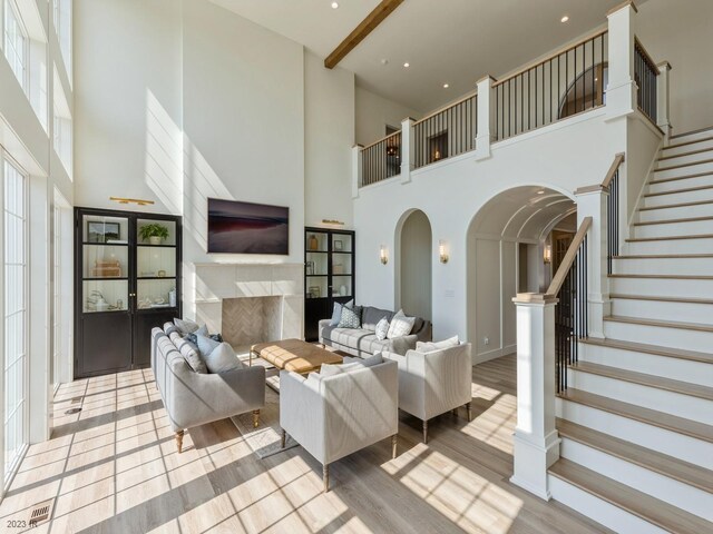 living room with a towering ceiling and light hardwood / wood-style floors