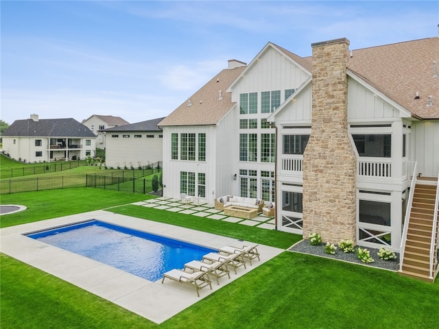 back of property featuring a fenced in pool, an outdoor hangout area, a patio area, and a yard