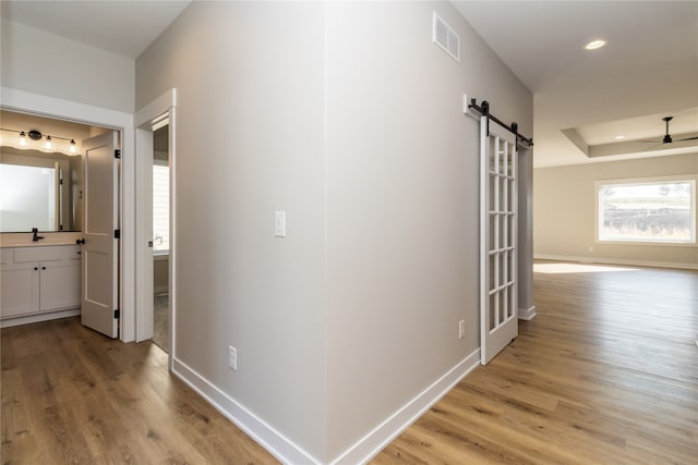 hallway featuring a barn door and light wood-type flooring