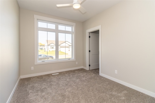 carpeted empty room with ceiling fan and a healthy amount of sunlight