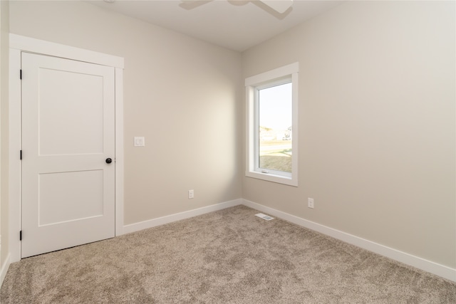 empty room with ceiling fan and light colored carpet