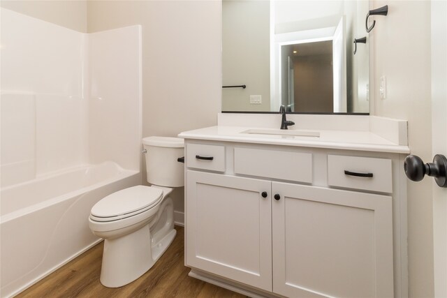 full bathroom with shower / bath combination, hardwood / wood-style flooring, vanity, and toilet