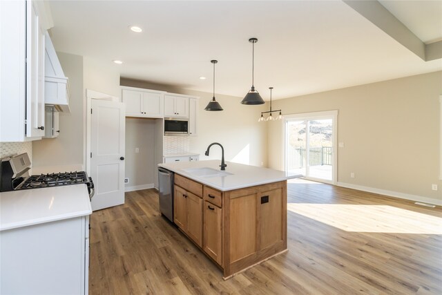 kitchen featuring light hardwood / wood-style floors, a kitchen island with sink, sink, white cabinetry, and appliances with stainless steel finishes