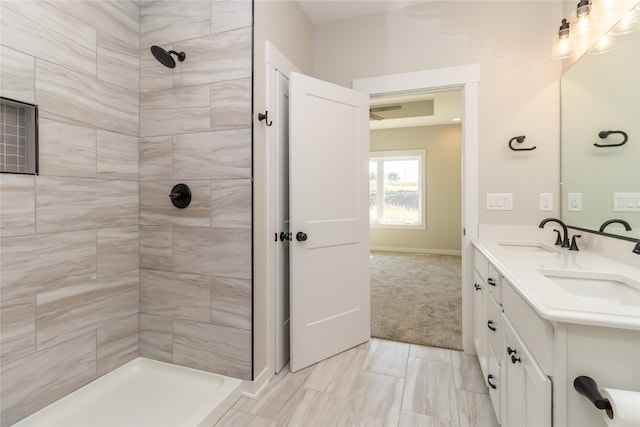 bathroom with a tile shower and vanity