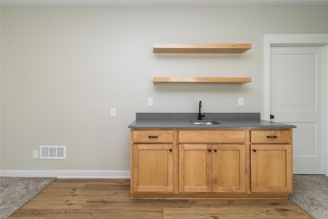 bar with hardwood / wood-style flooring and sink